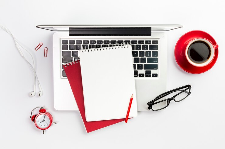 overhead-view-office-supplies-laptop-coffee-cup-alarm-clock-spectacles-white-desk_23-2148178604